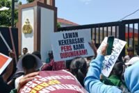 Mahasiswa berunjuk rasa di depan Polda NTT pada 11 Oktober 2024, saat Pemimpin Redaksi Floresa, Herry Kabut sedang melaporkan kasus dugaan penganiayaan.